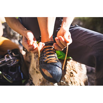 Rock Climber Putting On Bouldering Shoes